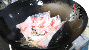 魚(yú)頭處理干凈后對半切開(kāi)，入加熱油的鍋中略煎。