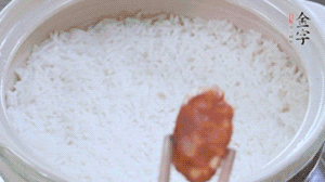 煮開(kāi)后轉小火，當米飯出現小孔時(shí)，鋪上金字麻辣香腸。