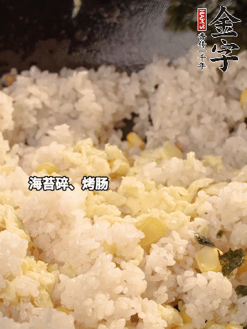 剩米飯下鍋炒散，依次下玉米粒、雞蛋、烤腸、海苔碎翻炒均勻。