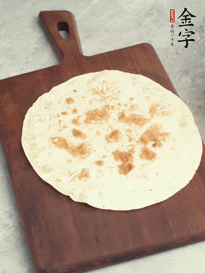 食材依次鋪在卷餅皮上，卷起來(lái)。