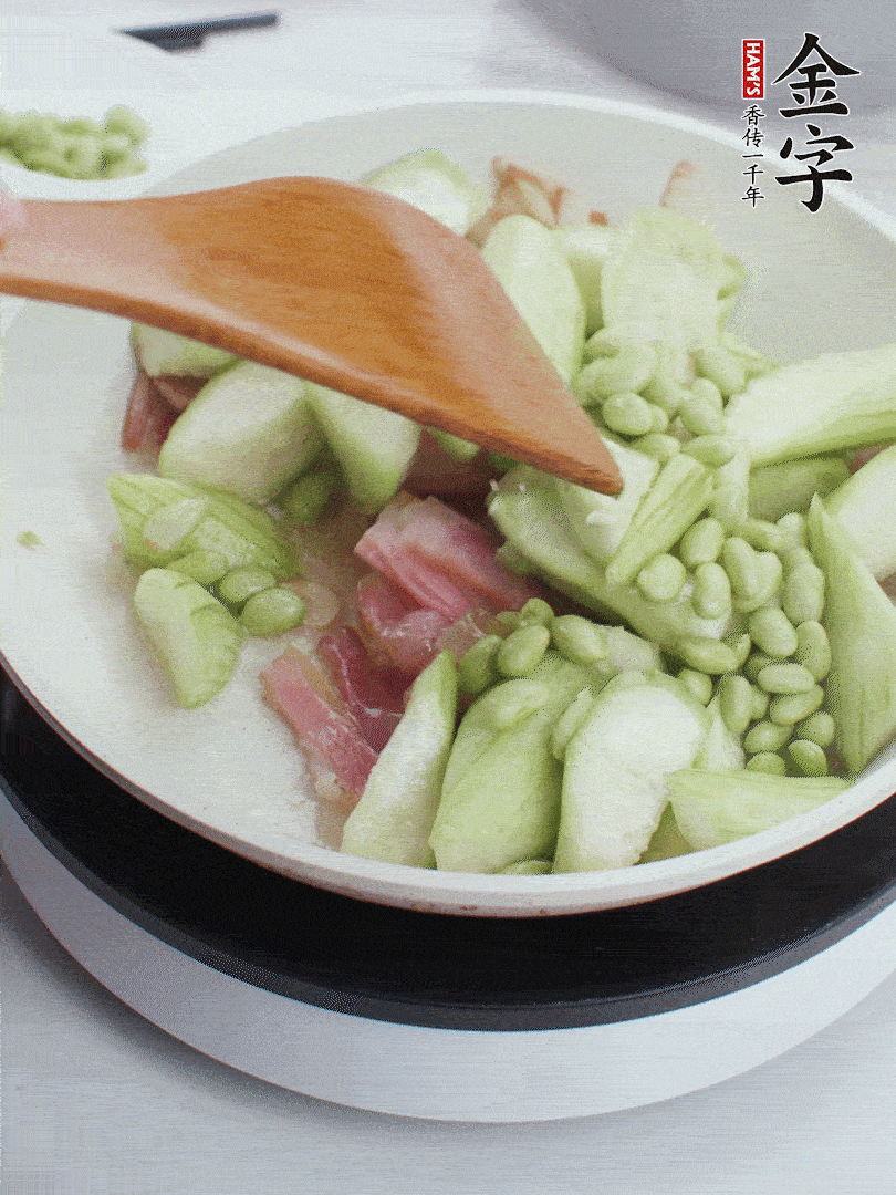 依次下絲瓜、青豆翻炒，炒至絲瓜打蔫縮小。