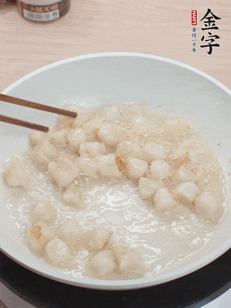 油溫4成熱，鮮貝蘸干淀粉下鍋煎，一面微黃后翻面。