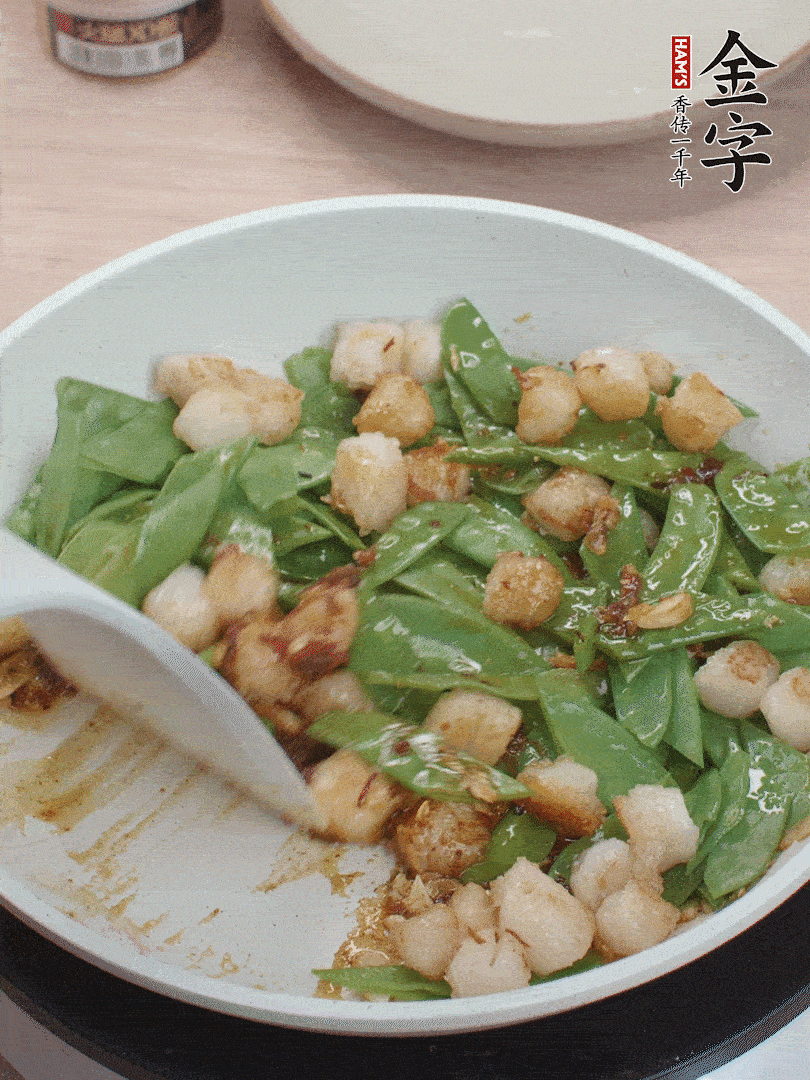 下甜豆莢、鮮貝輕輕翻炒均勻。