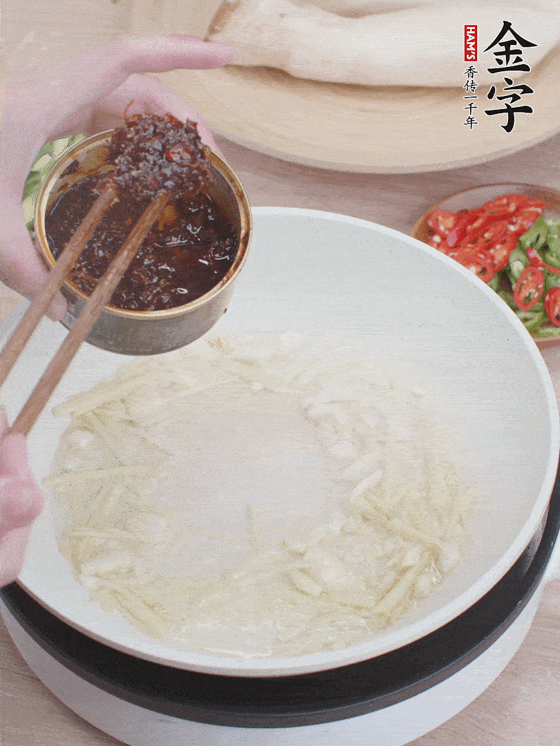 起鍋熱油，姜蒜、金字火腿干貝醬煸香。