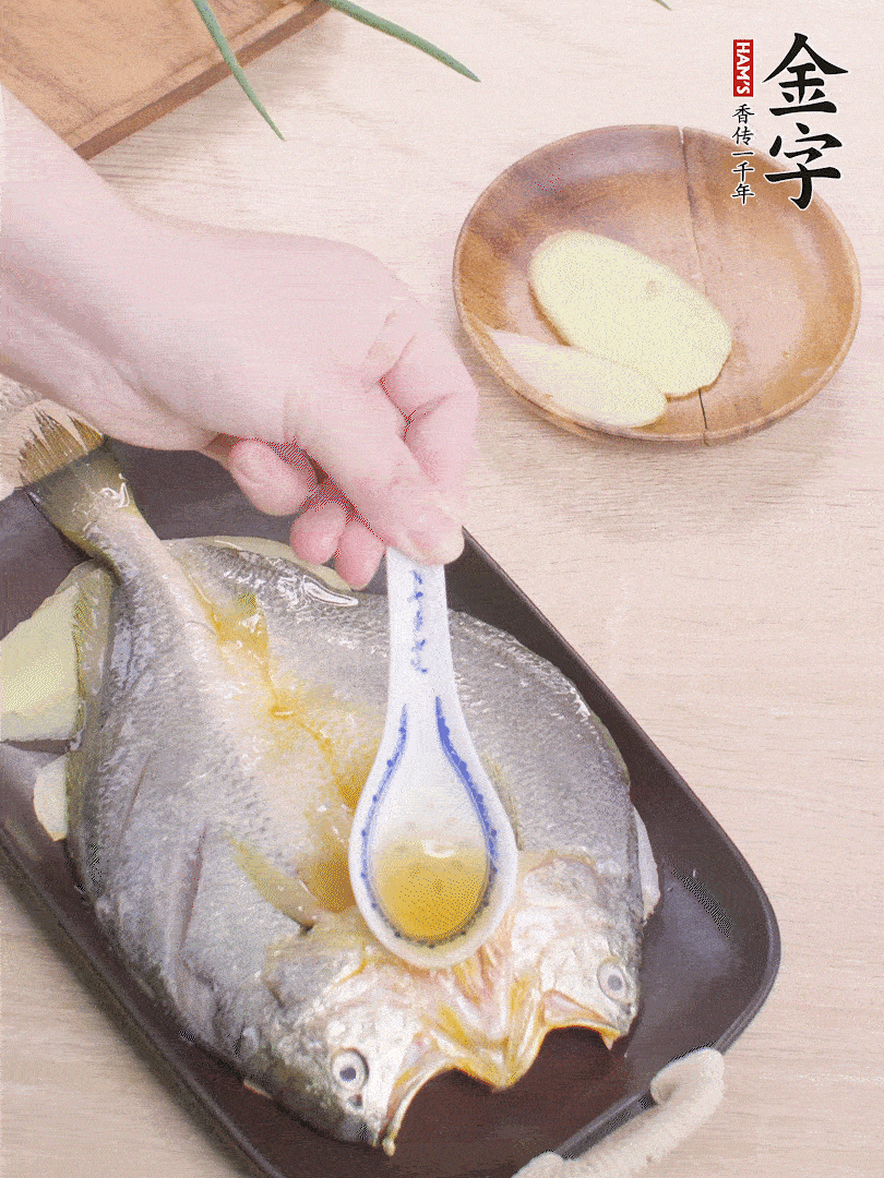 盤(pán)底鋪姜片，放黃魚(yú)，淋2勺料酒。