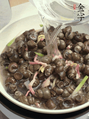 倒處理干凈的螺螄翻炒，加3勺料酒。加清水蓋過(guò)螺螄，中火蓋蓋煮5分鐘。