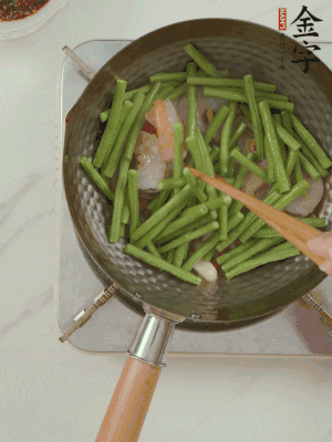 下掰好的缸豆段翻炒，略燜煮。