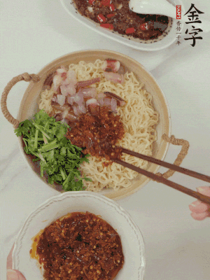 在面上鋪魷魚(yú)、香菜、金字火腿大師醬。